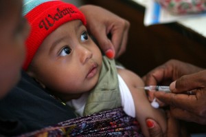 A health worker vaccinates a toddler.